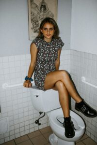 Girl sitting on Toilet