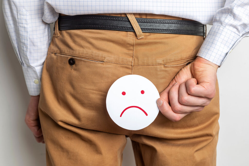 Man holding paper sad face behind his backside